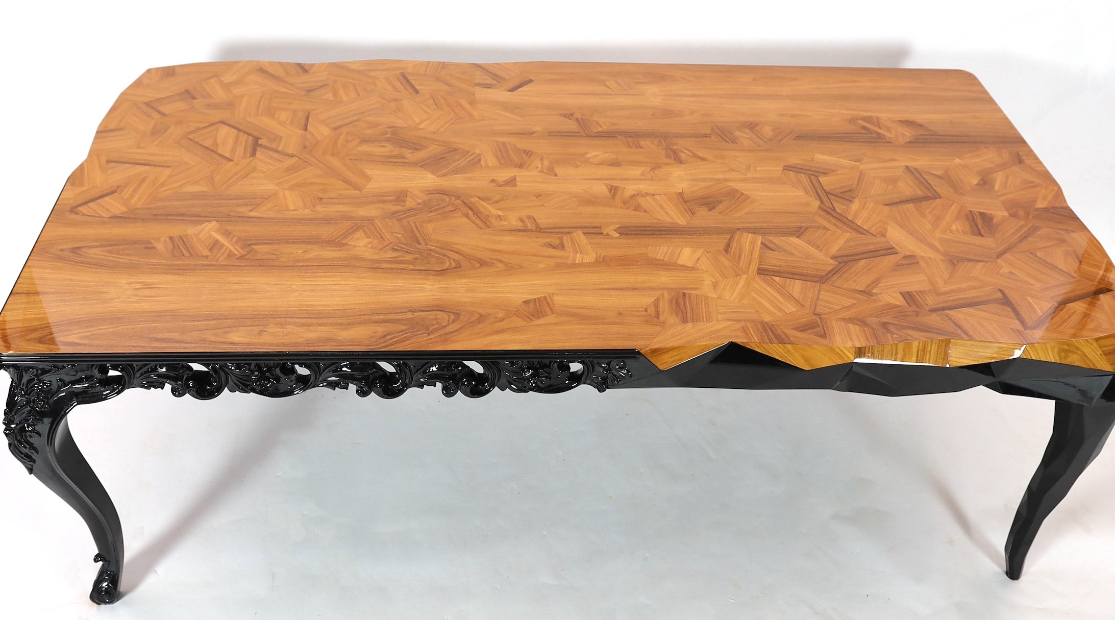 A contemporary Boca Do Lobo palissandre and black lacquer 'Royal' dining table, with parquetry veneered top on ebonised underframe with cabriole legs, scroll carved to two opposing legs and geometric carving to the other